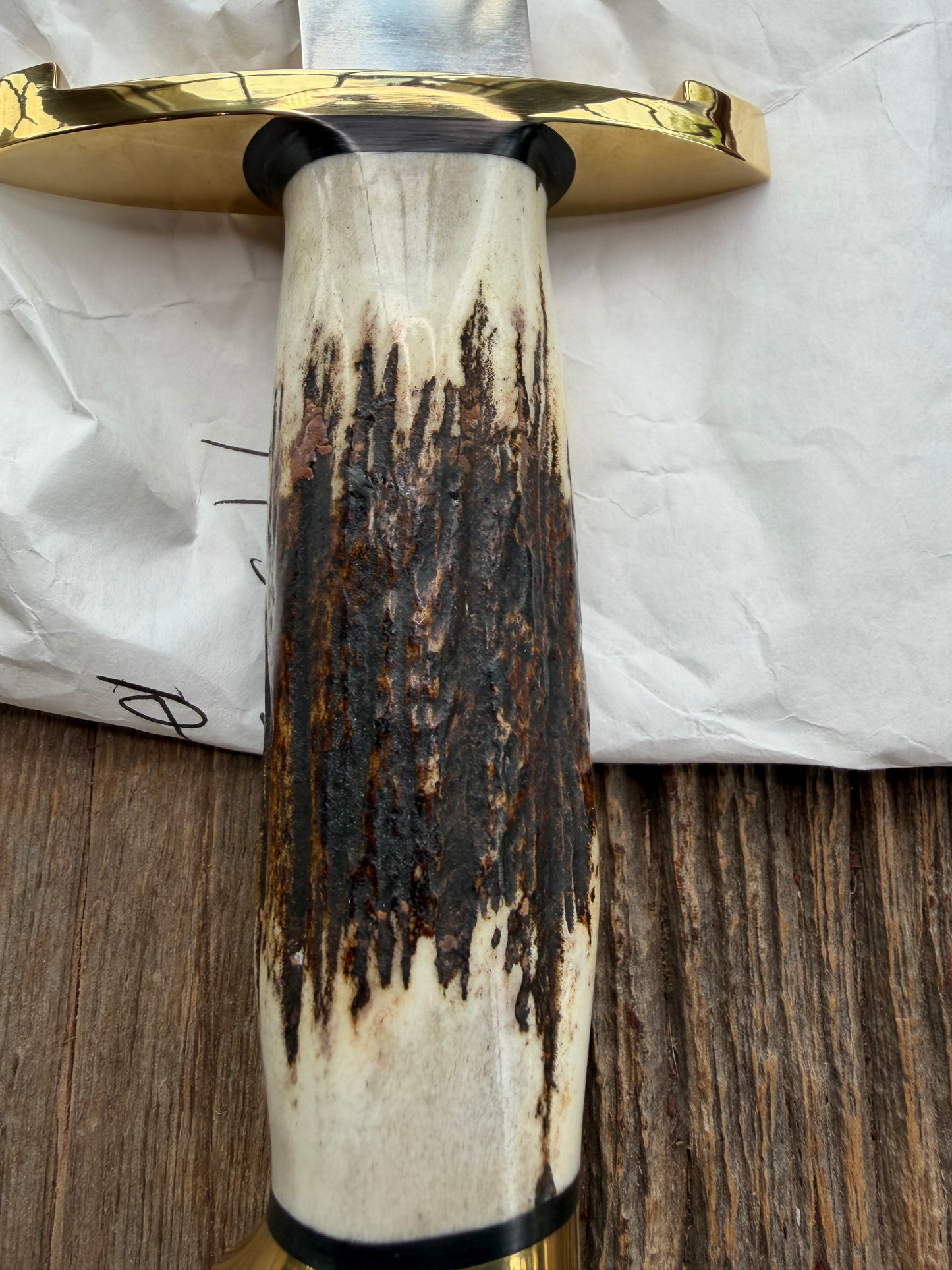 New in paper fresh from the Shop. Randall Knife Model 14-7.5 Big. Nice piece of Stag, Gorgeous Brass Lugged hilt and brass crows beak butt cap. Single black spacer. Stainless steel.