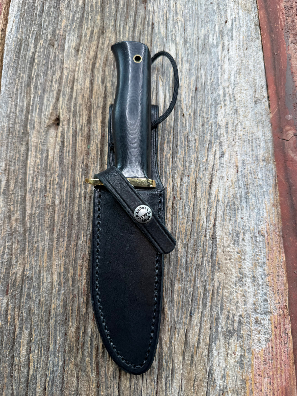 Nice Randall Model 28 Woodsman in Black Micarta. SS blade, brass single hilt. Lanyard hole. Black leather sheath.